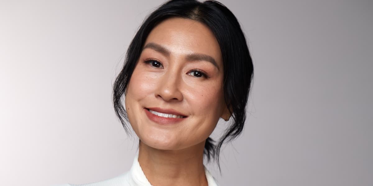 Portrait of Kathy Uyen, arms folded, smiling
