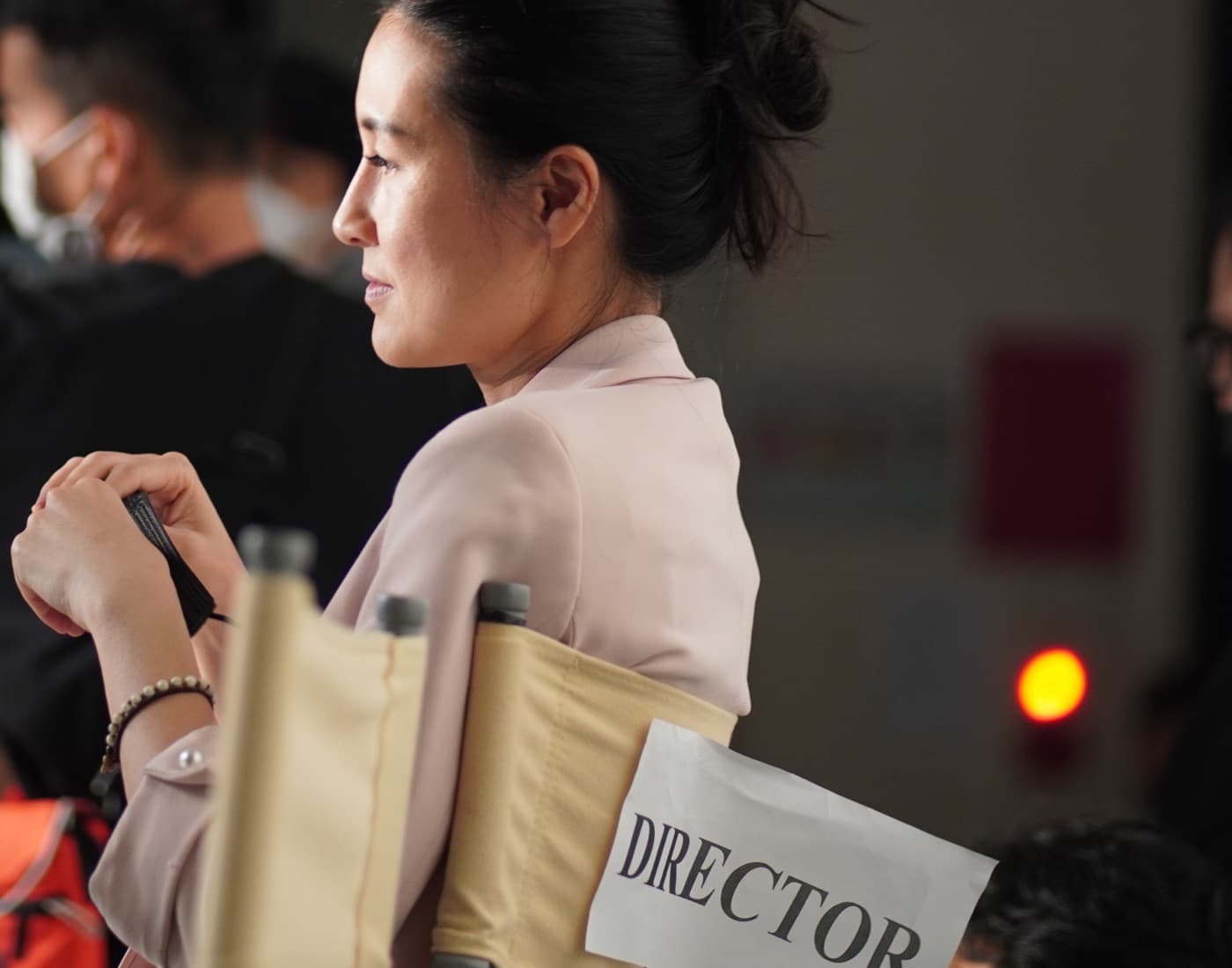 Kathy Uyen on set, seated in the director's chair marked DIRECTOR